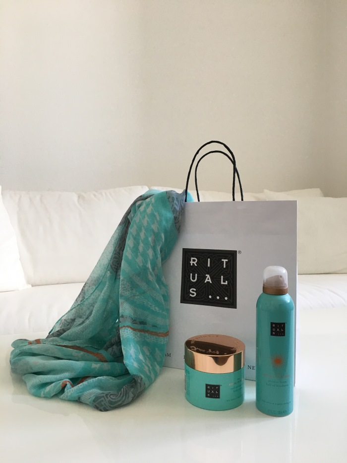 Rituals Dusche und Bodycreme neben mit einem gleichfarbigem Tuch und der Einkaufstüte